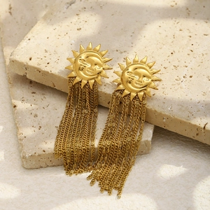 Macro detail of 18K gold plated sun face stud earring with dangling tassel chains