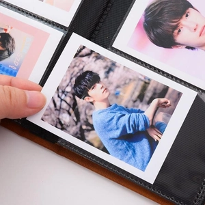Detailed view showing hands inserting a mini photo into the velvet photo album sleeve