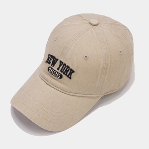 Close-up of khaki baseball cap with New York 1625 embroidery and vintage cotton texture