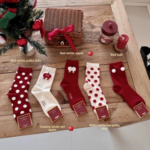Flat lay of five pairs of red and white Christmas knit cotton socks with holiday embroidery
