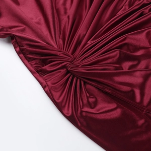 Gros plan détaillé du tissu satiné bordeaux avec un nœud torsadé élégant et des plis