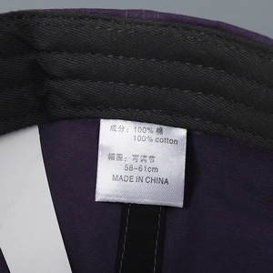 Detailed macro view of internal 100 percent cotton care label on purple baseball cap