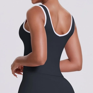 Détail du haut de sport noir avec dos en U profond et liserés blancs contrastants