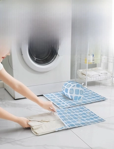 Detail of mesh laundry bag with blue geometric pattern and secure zipper protector