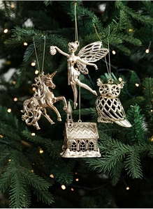 Addobbi natalizi dorati a forma di angelo e unicorno su un albero di Natale luminoso