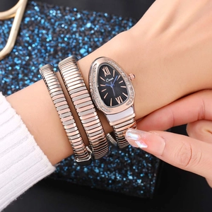 Macro shot of rose gold snake bracelet watch with sparkling crystal case and black dial