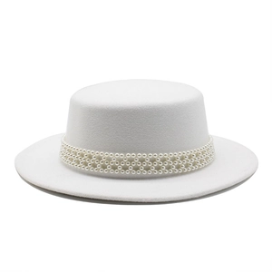 Detail of elegant white wool boater hat featuring three rows of woven pearl trim decoration