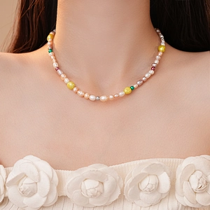 Gros plan d'un collier en perles d'eau douce baroques colorées porté par un mannequin