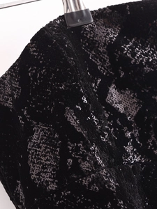 Macro di paillettes geometriche su abito in velluto nero per un look da sera elegante