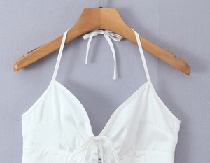 Détail du haut en satin blanc avec décolleté en V plissé et liens de cou ajustables