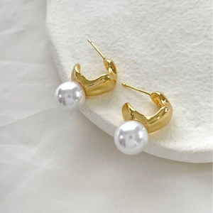 Boucles d'oreilles élégantes en métal doré irrégulier avec perle pour femme sur pierre