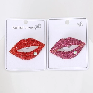 Detail of red and pink crystal lip brooches with colorful rhinestones on card