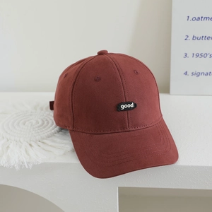 Detail of burgundy cotton baseball cap with black cloud-shaped 'good' embroidered patch