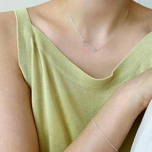 Detail of 925 sterling silver necklace and bracelet set with blue beads on model