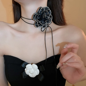 Close-up of black mesh flower choker with rhinestone trim and long ribbon ties