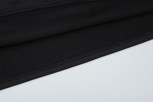 Détail des coutures plates et des finitions soignées sur une robe courte noire dos nu