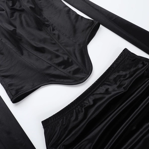 Dettaglio di un set due pezzi nero attillato in tessuto lucido con scollo quadrato elegante