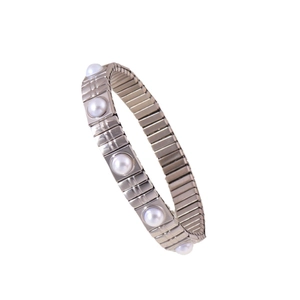 Bracciale elastico in acciaio inossidabile con cinque perle d'acqua dolce su fondo bianco