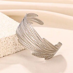 Detailed view of wide stainless steel cuff bracelet with intricate hollow feather texture