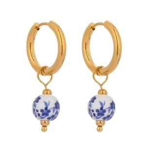 Close-up of golden hoop earrings with blue and white floral ceramic beads