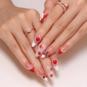 French tip press-on nails with 3D cherry, red hearts, white pearls, and glitter accents
