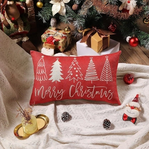 Red Christmas lumbar pillow cover with Merry Christmas text and trees on a festive sofa