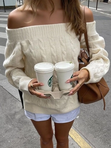 Detail of off-white off-shoulder cable knit sweater and matching blue striped shorts