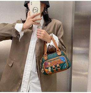 Detail of color-block soft faux leather crossbody bag with studs and vintage handle