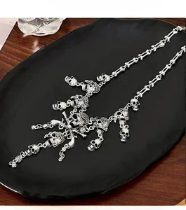 Gothic skull necklace with bone-shaped chain and vintage silver skull pendants on tray