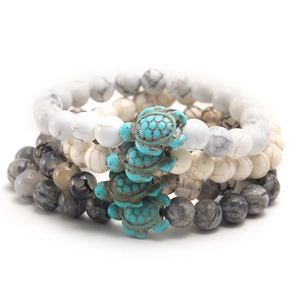 Set of three elastic natural stone bracelets with turquoise turtle charms on white background