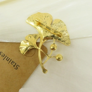 Elegant 18k gold ginkgo leaf brooch featuring detailed texture and secure pin closure