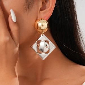 Close-up of geometric gold and silver mixed metal square drop earrings on model