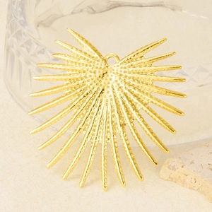 Macro shot of gold stainless steel heart pendant with sunburst spikes and polished finish