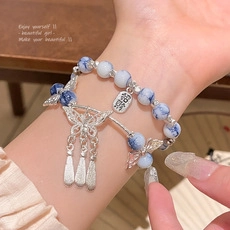 Detail of a double-layer Chinese style bracelet with marble beads and butterfly charms