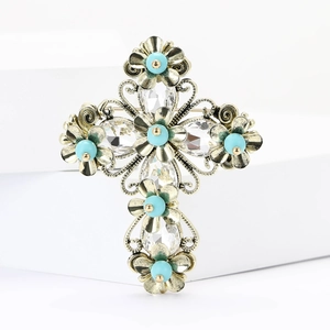 Detail of vintage bronze cross brooch with turquoise beads and sparkling rhinestones