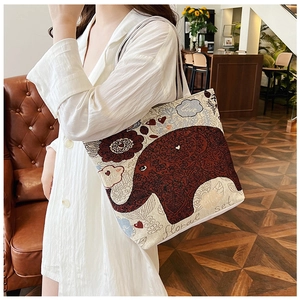 Detailed close-up of ethnic canvas tote bag with red elephant and floral embroidery