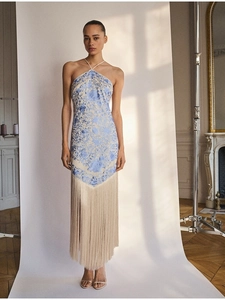 Detail of elegant halter neck maxi dress with blue floral embroidery and fringe hem