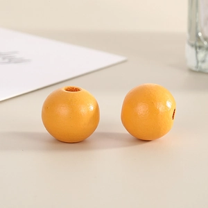Macro view of 16mm orange painted wooden beads with smooth finish and central hole