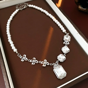 Macro view of crystal flower necklace with pearl details in a luxury gift box