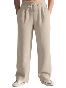 Detail of beige ribbed knit trousers with drawstring elastic waist and vertical texture