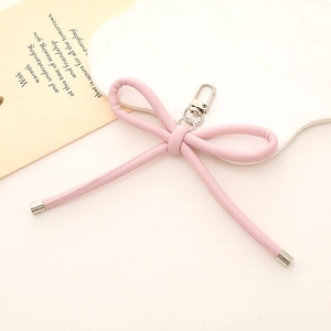 Pink faux leather bow keychain with heart pendant and metallic clasp for bags