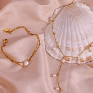Détail de l'ensemble de bijoux en perles dorées avec collier et bracelet sur soie