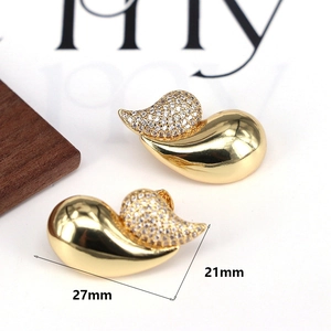Macro shot of gold teardrop earrings with pave zircons and size dimensions 27mm by 21mm