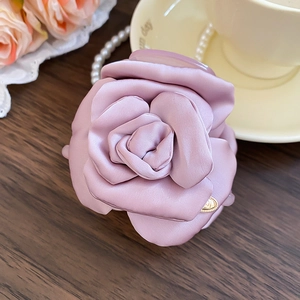 Dettaglio della molletta per capelli con rosa in raso rosa cipria e cuore dorato