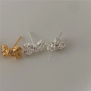 Detailed close-up of three 925 sterling silver bow knot stud earrings in gold and silver