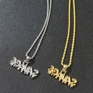 Detail of silver and gold Savage word pendants with iced out crystals and rope chains