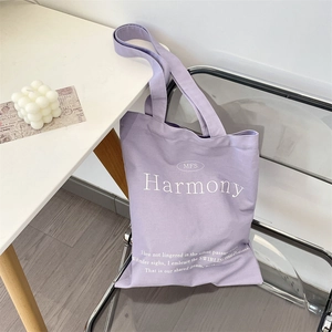 Close-up of Harmony letter print on the purple minimalist canvas tote bag fabric