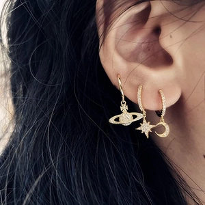 Asymmetric gold star and moon drop earrings with zircon crystals on female model