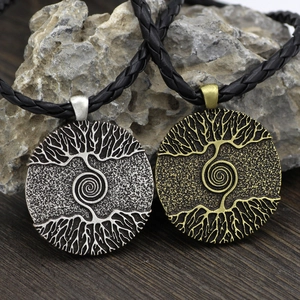 Detail showing two Yggdrasil pendants in silver and bronze with black braided cords