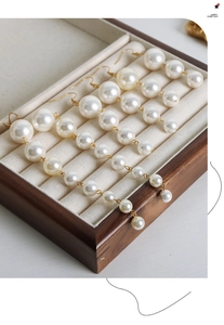 Macro view of vintage pearl tassel earrings in various lengths displayed in a jewelry box